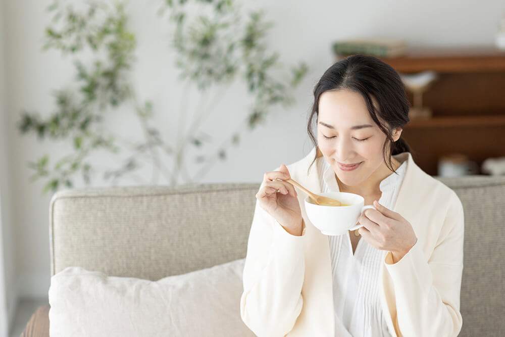 デキストリン入りのコーンスープを飲む女性