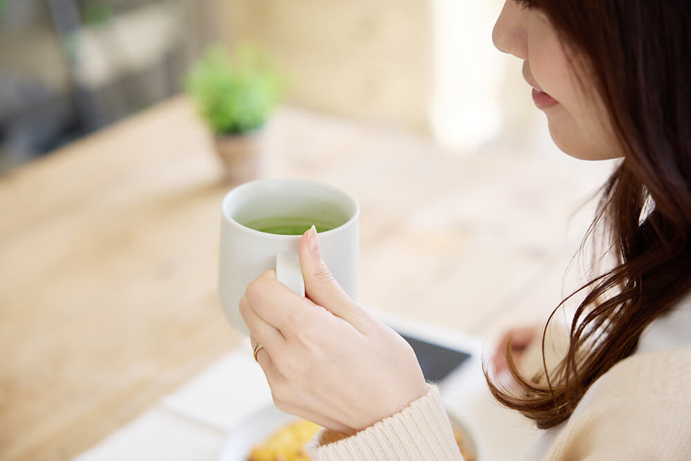 朝に抹茶を飲む女性