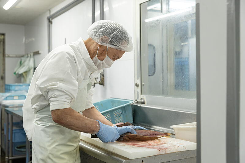 株式会社ふじと屋のベテランスタッフが魚を捌く様子